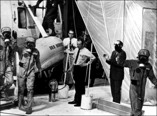 Apollo 11 crew step from helicopter