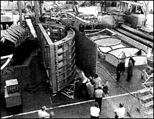 the skin panel is being positioned for attachment to the curved restraining fixture