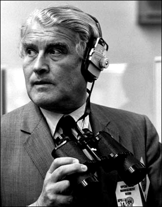 Wernher von Braun, by this time the NASA deputy associate administrator for future programs, uses binoculars to monitor data on closed-circuit television screens in Firing Room 2 of the Launch Control Center during the final Apollo 14 launch preparations on January 31, 1971